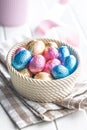 Chocolate easter eggs wrapped in multi colored foil in bowl on white table Royalty Free Stock Photo