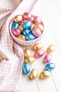 Chocolate easter eggs wrapped in multi colored foil in bowl on white table Royalty Free Stock Photo