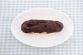 Chocolate eclair cream puff on plate on table Royalty Free Stock Photo