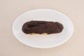 Chocolate eclair cream puff on plate on table Royalty Free Stock Photo