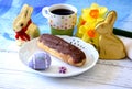 Chocolate eclair pastry with coffee and chocolate bunnies Royalty Free Stock Photo