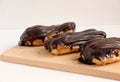 Chocolate eclair on wooden desk food photography. Bekery, cake , choco, pie, confectionary, cream. Three fresh eclairs with chocol