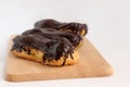 Chocolate eclair on wooden desk food photography. Bekery, cake , choco, pie, confectionary, cream. Three fresh eclairs with chocol