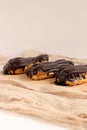 Chocolate eclair on wooden desk food photography. Bekery, cake , choco, pie, confectionary, cream. Three fresh eclairs with chocol