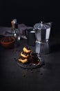 Chocolate eclairs with a cup of coffee and a coffee pot