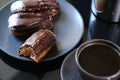 Chocolate eclairs on a plate and cup of coffee. traditional fcench Chocolate Eclairs