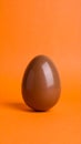 Chocolate Egg on Orange Background for Easter or Celebration Royalty Free Stock Photo