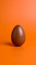 Chocolate Egg on Orange Background Studio Shot Easter Concept Royalty Free Stock Photo