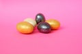 Chocolate eggs on a pink background for Easter. The eggs are multicolored. Happy Easter. Chocolate. Sweets for children and adults