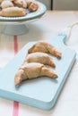 Chocolate filled crescent rolls (croissants) with ice sugar topping arranged on plate and cutting board