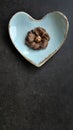 Chocolate flavor, Brown color, Sam Pan Nee traditional Thai handcraft snack on pastel blue heart shape plate, Dark background, Royalty Free Stock Photo