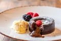 Chocolate fondant cupcake with raspberries, ice creme and powdered sugar placed on plate Royalty Free Stock Photo