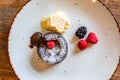 Chocolate fondant cupcake with raspberries, ice creme and powdered sugar placed on plate Royalty Free Stock Photo