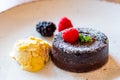 Chocolate fondant cupcake with raspberries, ice creme and powdered sugar placed on plate Royalty Free Stock Photo