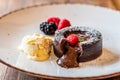 Chocolate fondant cupcake with raspberries, ice creme and powdered sugar placed on plate Royalty Free Stock Photo