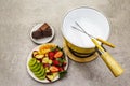 Chocolate fondue. Assorted fresh fruits, two types of chocolate. Ingredients for cooking a sweet romantic dessert. Stone concrete