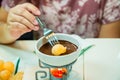 Chocolate fondue. hands female, with fruit.Girl eat chocolate fondue romantic dessert dinner. Royalty Free Stock Photo