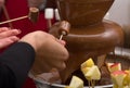 Chocolate fountain and extends a hand to it