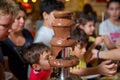 Chocolate fountain with fruits. Children birthday party . Homemade chocolate fountain fondue with marshmallow on a skewer dripping