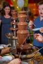 Chocolate fountain with fruits. Children birthday party . Homemade chocolate fountain fondue with marshmallow on a skewer dripping