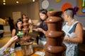 Chocolate fountain with fruits. Children birthday party . Homemade chocolate fountain fondue with marshmallow on a skewer dripping