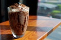 Chocolate frappe with whip cream and blueberry on wooden table in cafe
