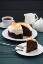 Chocolate fruit cake with cream cheese glasing and orange peel served with black tea on dark background Royalty Free Stock Photo