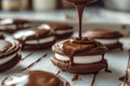 Chocolate ganache being poured on marshmallow filled cookies