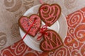 Chocolate gingerbread cookies heart shaped with red and pink icing on white plate Royalty Free Stock Photo