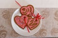 Chocolate gingerbread cookies heart shaped with red and pink icing on white plate Royalty Free Stock Photo