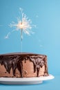 Chocolate glazed birthday cake with a sparkler. New year cake Royalty Free Stock Photo