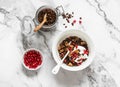 Chocolate granola with greek yogurt, pomegranate, dried figs - delicious breakfast on a light background, top view