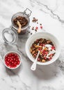 Chocolate granola with greek yogurt, pomegranate, dried figs - delicious breakfast on a light background, top view