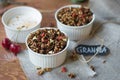 Chocolate granola in two cups with goji and milk