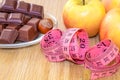 Chocolate with hazelnuts, a meter and fruits, apples, bananas, greyfruit. Chocolate or fruit diet.
