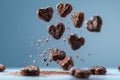 Chocolate heart cookies in motion against calming blue background