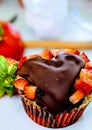 Chocolate, heart-shaped cupcake covered by strawberries, vertical Royalty Free Stock Photo