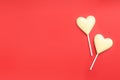 Chocolate heart shaped lollipops on red background, flat lay. Space for text Royalty Free Stock Photo