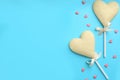 Chocolate heart shaped lollipops and sprinkles on light blue background, flat lay. Space for text Royalty Free Stock Photo