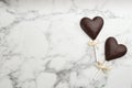 Chocolate heart shaped lollipops on white marble table, flat lay. Space for text Royalty Free Stock Photo