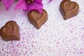 Chocolate hearts on a white background with pink glitter