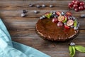 Chocolate homemade cake with fresh blueberries and red grapes, mint on a wooden brown background, blue towel, berry pie Royalty Free Stock Photo