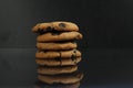 Chocolate homemade holiday cookies with chocolate drops are stacked on top of each other with a reflection side view of copy space