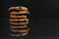 Chocolate homemade holiday cookies with chocolate drops are stacked on top of each other with a reflection side view of copy space