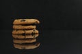 Chocolate homemade holiday cookies with chocolate drops are stacked on top of each other with a reflection side view of copy space