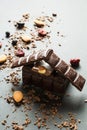 Chocolate house and dried berries with nuts on a black background, vertically