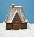 Chocolate House in powdered sugar like in the snow on blue background