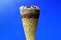 Chocolate ice cream cone on blue background Royalty Free Stock Photo