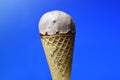 Chocolate ice cream cone on blue background