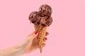 Chocolate ice cream cone on pink faded pastel color background.